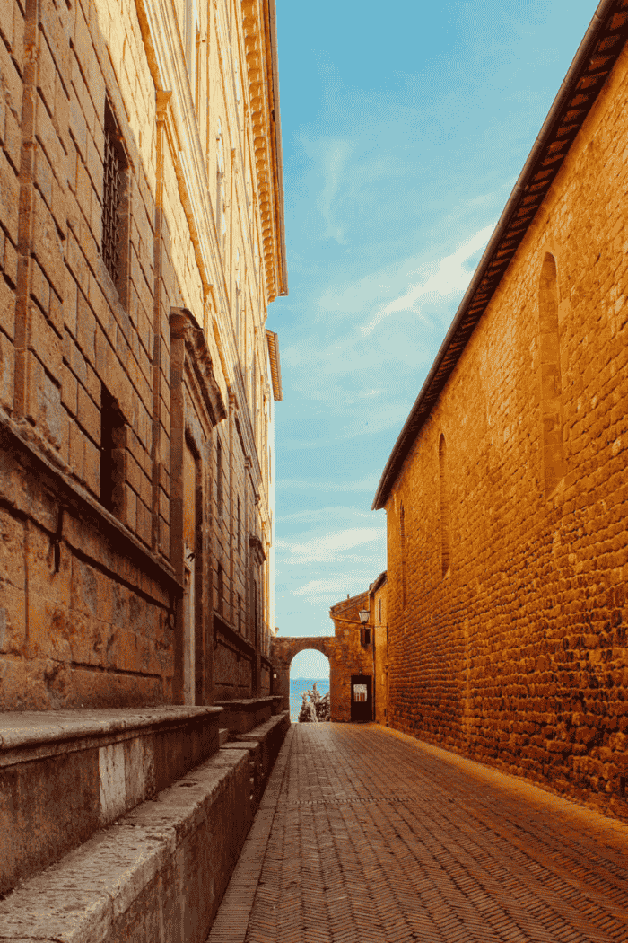 Gasse in Pienza mit Torbogen am Ende