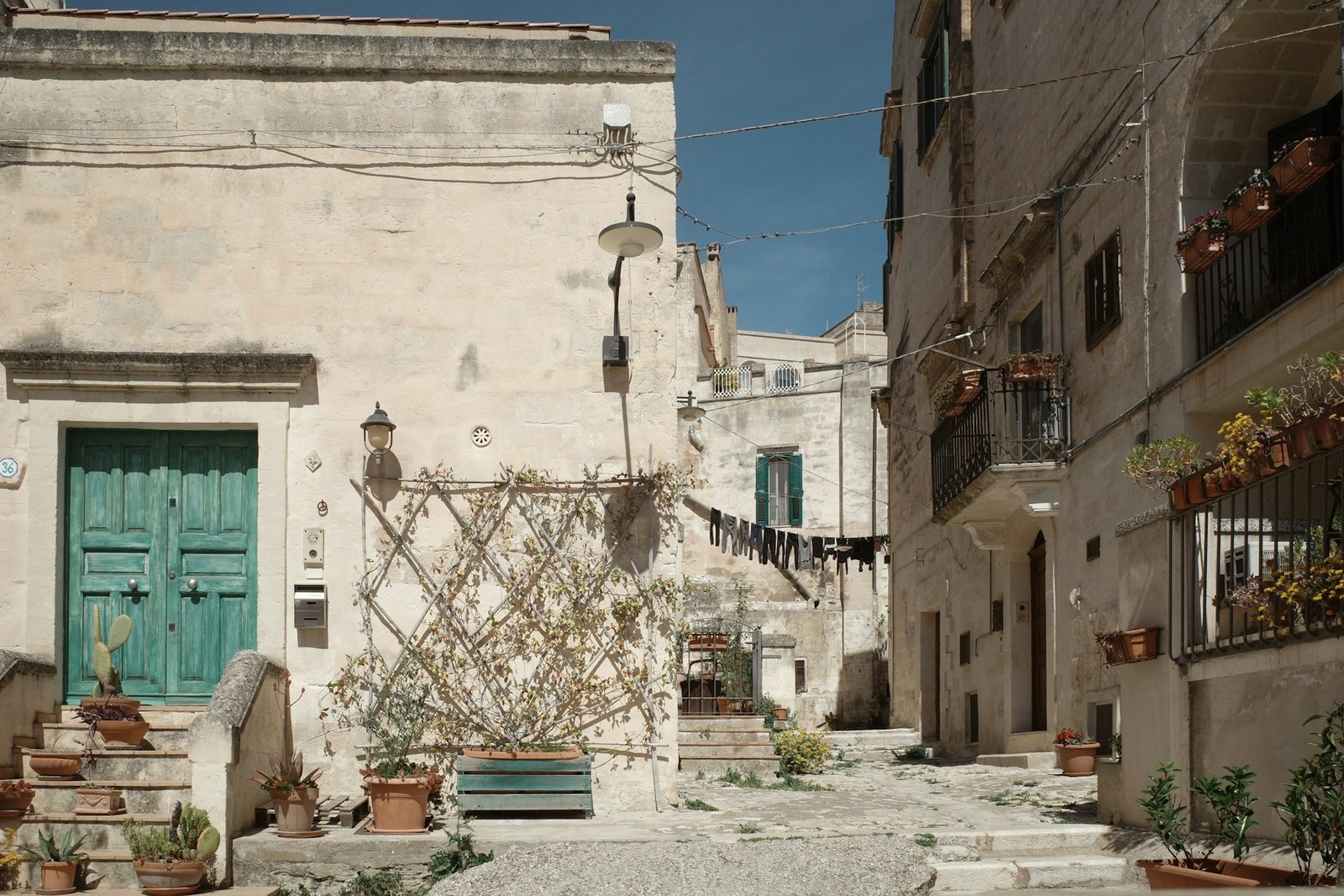 Ecke einer Gasse in Matera mit grüner Tür und Wäscheleine