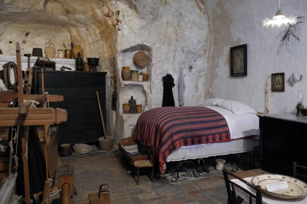 Originale Einrichtung in einer Höhle von Matera mit Bett