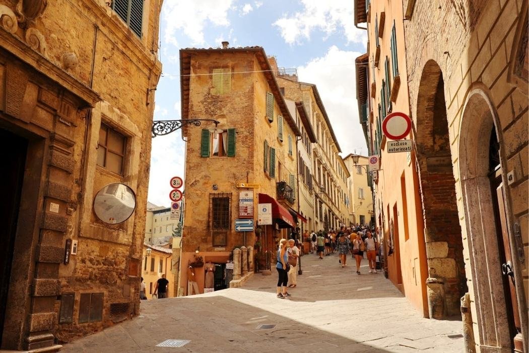 Gasse in Montepulciano mit Blick auf Straßenecke und Touristen