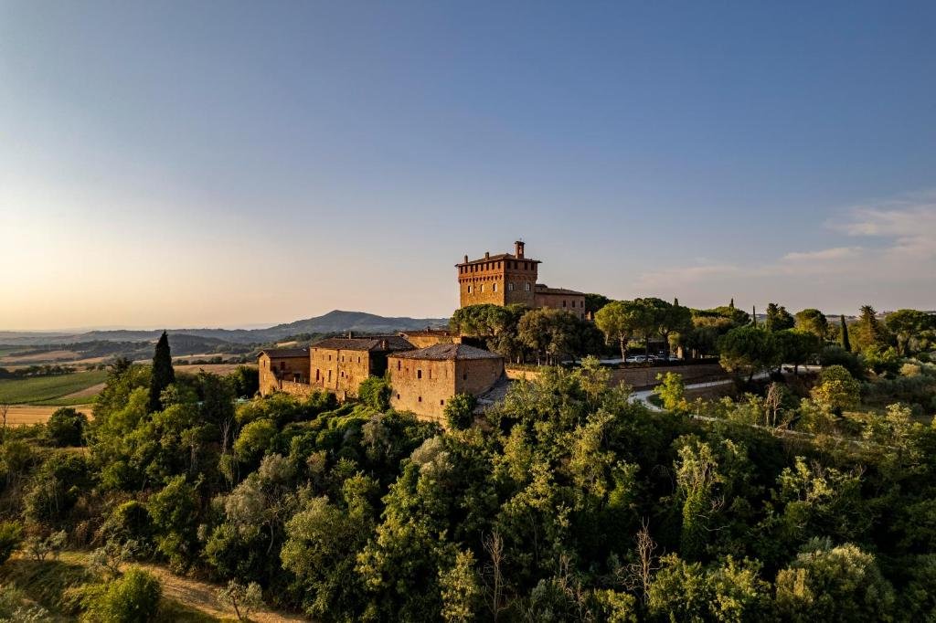 Burg in der Toscana zum Sonnenuntergang umgeben von Wald