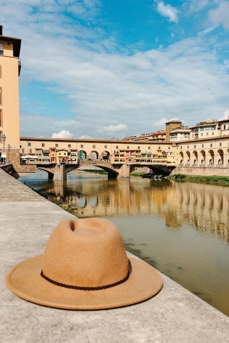 Blick auf Ponte Vecchio mit Hut im Vordergrund