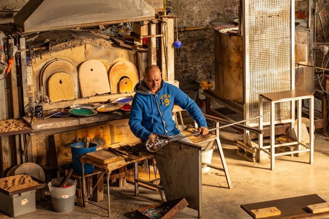 Glasbläser in seiner Werkstatt in Murano
