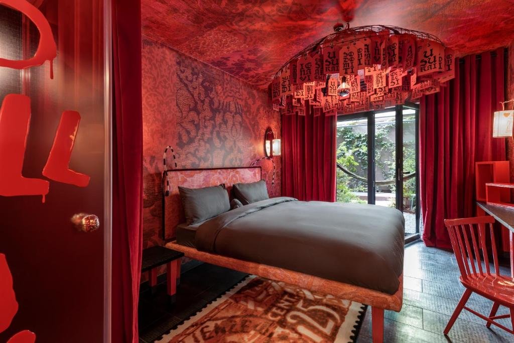 Hotelzimmer mit roter Tapete und Doppelbett in Florenz