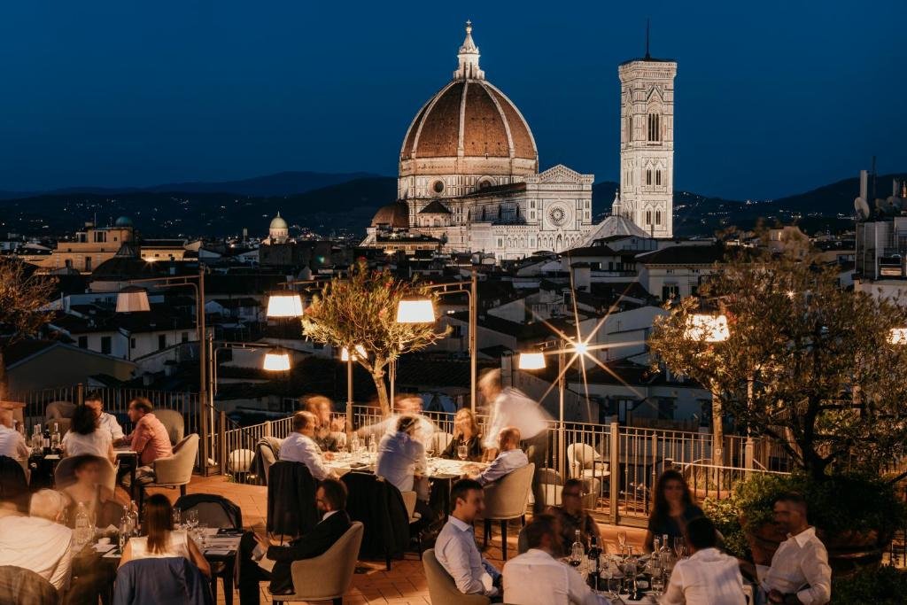 Dachterrasse abends im Hotel Baglioni mit Menschen am Tisch und Dom von Florenz im Hintergrund 