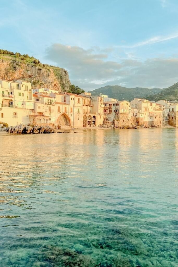 Blick auf Cefalú auf Sizilien vom Meer aus bei Sonnenuntergang