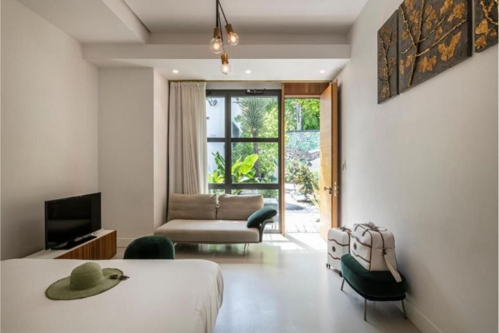 Helles Hotelzimmer mit Tür zum Garten