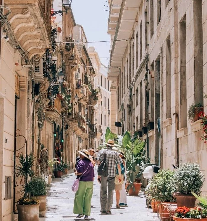Sonnige Gasse mit Touristen in Siracusa